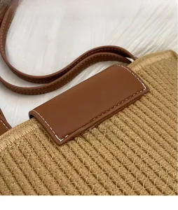 Close-up of hand-woven cotton rope bucket bag with brown leather lid and contrast stitching