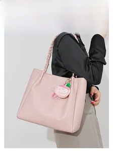 Détail du sac cabas rose à motif pied-de-poule avec poignée en corde et breloque pêche