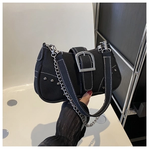 Close-up of black canvas bag with silver studs, metal buckle and contrast stitching