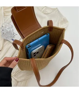Top view of woven shoulder bag showing spacious interior with tablet and phone