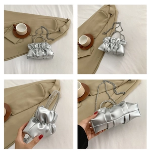 Detail of silver pleated cloud bag with rhinestone handle and metal chain strap