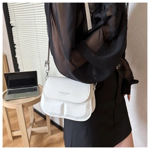 Detail van witte kunstlederen crossbodytas met geometrische textuur en Fashion Trend tekst