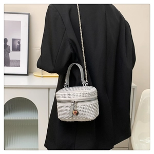 Detail of silver rhinestone handbag with leather handle and metal chain on a model