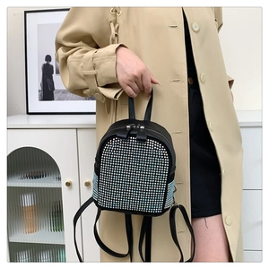 Détail d'un mini sac à dos noir avec strass colorés et fines bretelles en cuir