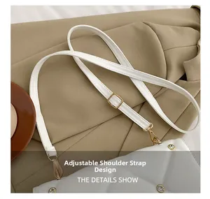 Detail of adjustable shoulder strap and gold buckle on a white quilted crossbody bag