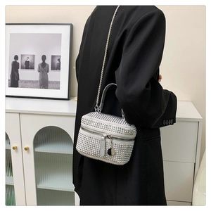 Close-up of sparkling rhinestone handbag with silver metal chain and top handle detail