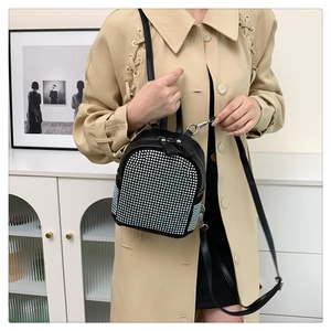 Detail of black mini rhinestone backpack with sparkling studs and metallic zipper accents