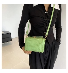 Détail du sac bandoulière vert citron avec texture plissée verticale et boucles métalliques