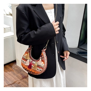 Détail du sac de selle bohème avec broderies colorées et pompons décoratifs
