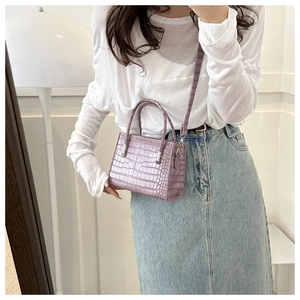 Detail of purple crocodile pattern tote bag with silver hardware and adjustable strap