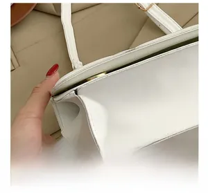 Close-up of precise stitching and metal buckle on a white quilted leather bag