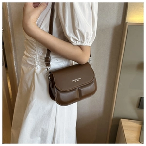 Detail van de bruine lederen crossbodytas met Fashion Trend print en zilveren metalen gesp