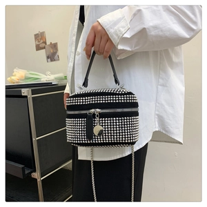 Detailed shot of black rhinestone handbag featuring silver studs and metallic chain strap