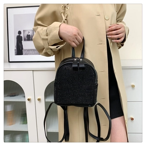 Détail d'un mini sac à dos noir avec rivets métalliques et finition cuir synthétique haut de gamme