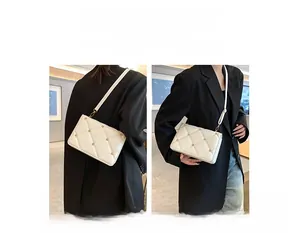 Detail showing white quilted shoulder bag with gold studs in crossbody and shoulder styles
