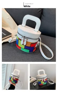 Detail view of colorful geometric cylinder bag with white leather and metal zipper