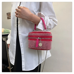 Macro shot of rose red velvet mini bag with silver rhinestones and metal chain strap