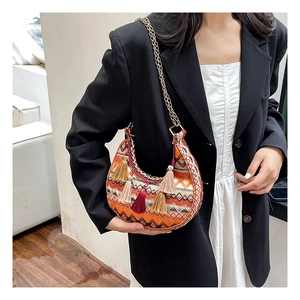 Détail du sac selle bohème tissé avec des glands colorés et une bandoulière chaîne
