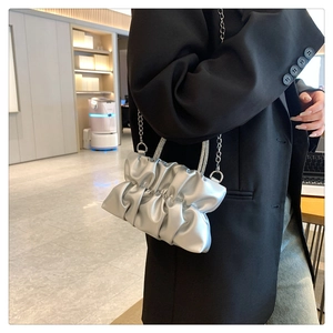 Détail du sac à main plissé argenté avec poignée en strass et bandoulière chaîne