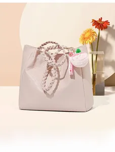 Détail du sac cabas rose avec texture pied-de-poule et poignée en cuir tressé