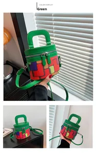 Detail view of colorful checkered cylinder bag with ring handle and dual metal zippers