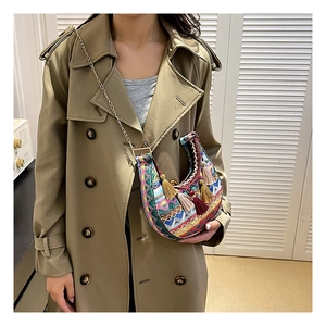 Détail d'un sac besace bohème avec motifs tissés colorés et pendentifs à pompons déco