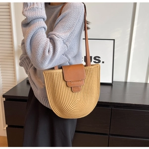 Detailed close-up of woven cotton rope shoulder bag with brown leather strap and magnetic flap