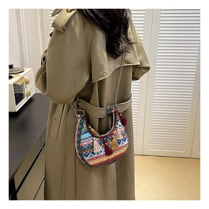 Gros plan du sac besace bohème avec glands colorés et bandoulière chaîne sur modèle