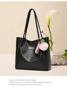 Détail du sac cabas pied-de-poule noir avec bandoulière tressée et pendentif pêche