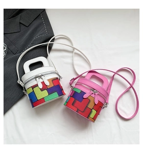 Detail view of colorful geometric cylinder bags with contrasting top flaps and dual zippers