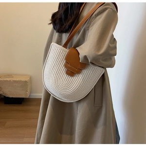 Detail of woven beige cotton rope bucket bag with premium brown leather strap on model