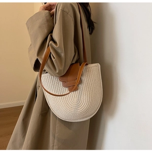 Detail of woven cotton rope shoulder bag with brown leather flap and contrast stitching