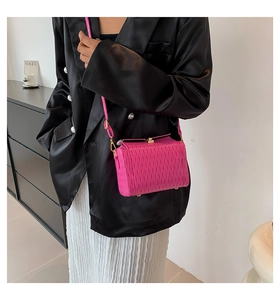 Détail du petit sac plissé rose fuchsia avec fermoir métallique doré et texture chic