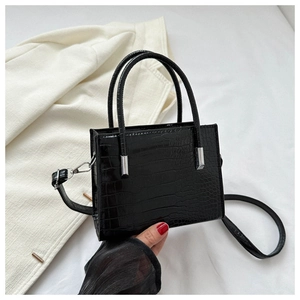 Detail of black stone pattern tote bag with crocodile texture and silver metal hardware