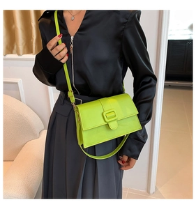 Neon green patent leather square crossbody bag with matching buckle and adjustable strap