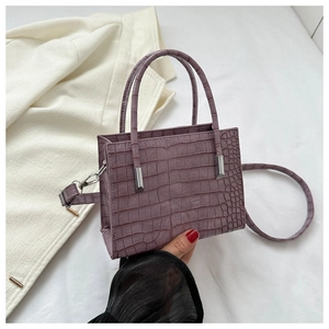 Detail of purple croc-embossed small handbag with silver hardware and dual handles