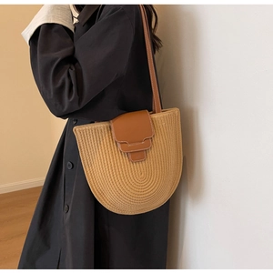 Detail of woven texture and brown leather flap on a vintage retro bucket shoulder bag