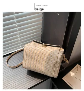 Dettaglio della borsa a tracolla beige strutturata con trama ondulata e chiusura dorata