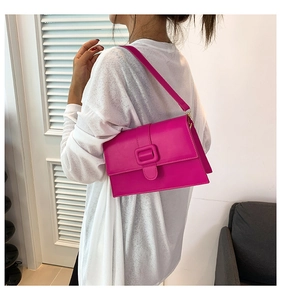 Hot pink rectangular leather shoulder bag shown on model with chic buckle detail