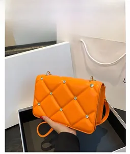 Detail view of orange quilted PU leather bag with sparkling rhinestone embellishments