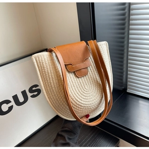 Detailed close-up of woven cream cotton rope texture and brown leather strap on bucket bag