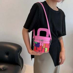 Pink cylinder bucket bag with colorful geometric patterns and adjustable shoulder strap