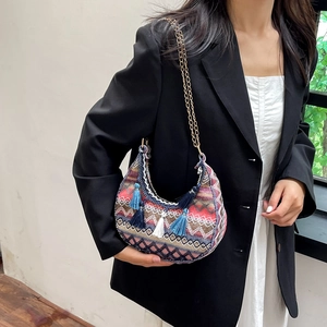 Sacoche bohème tissée avec pompons colorés et bandoulière chaîne dorée sur mannequin