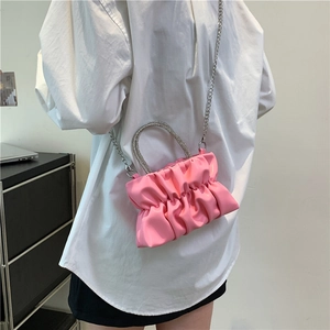 Sac froissé rose avec poignée en strass et bandoulière chaîne sur modèle