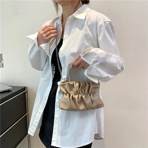 Sac nuage plissé kaki avec poignée en strass et bandoulière porté par un mannequin