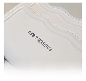 Detail of white leather bag with scalloped edges and Fashion & Bag printed text