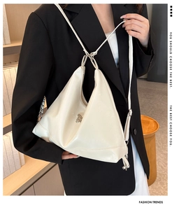 Detail of white glossy geometric handbag with silver butterfly clasp and soft PU texture
