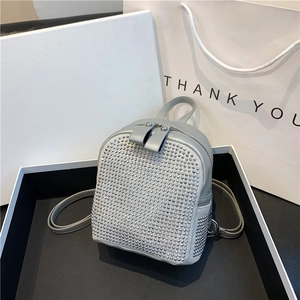 Close-up of light grey mini backpack featuring dense silver rhinestones and adjustable straps