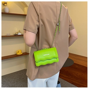 Détail du sac chaîne vert néon avec bordure ondulée et ajusteur à bille argentée