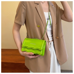 Détail du sac vert vif avec texture ondulée et logo Fashion & Bag porté par un mannequin
